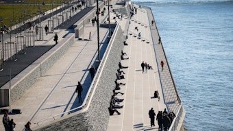 Menschen sitzen auf Treppen am Rheinufer