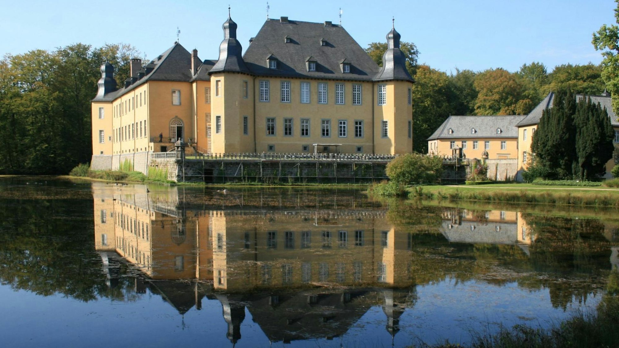 Wasserschloss Schloss Dyck spiegelt sich im See.