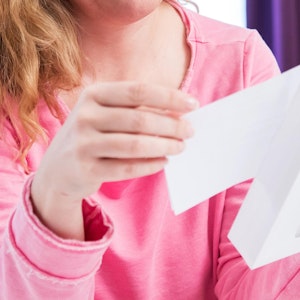 Eine Frau öffnet einen Briefumschlag.