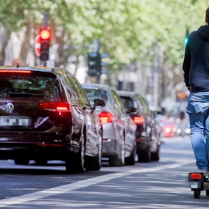Ein Mann fährt in Köln auf einem E-Scooter.
