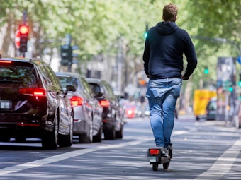 Ein Mann fährt in Köln auf einem E-Scooter.