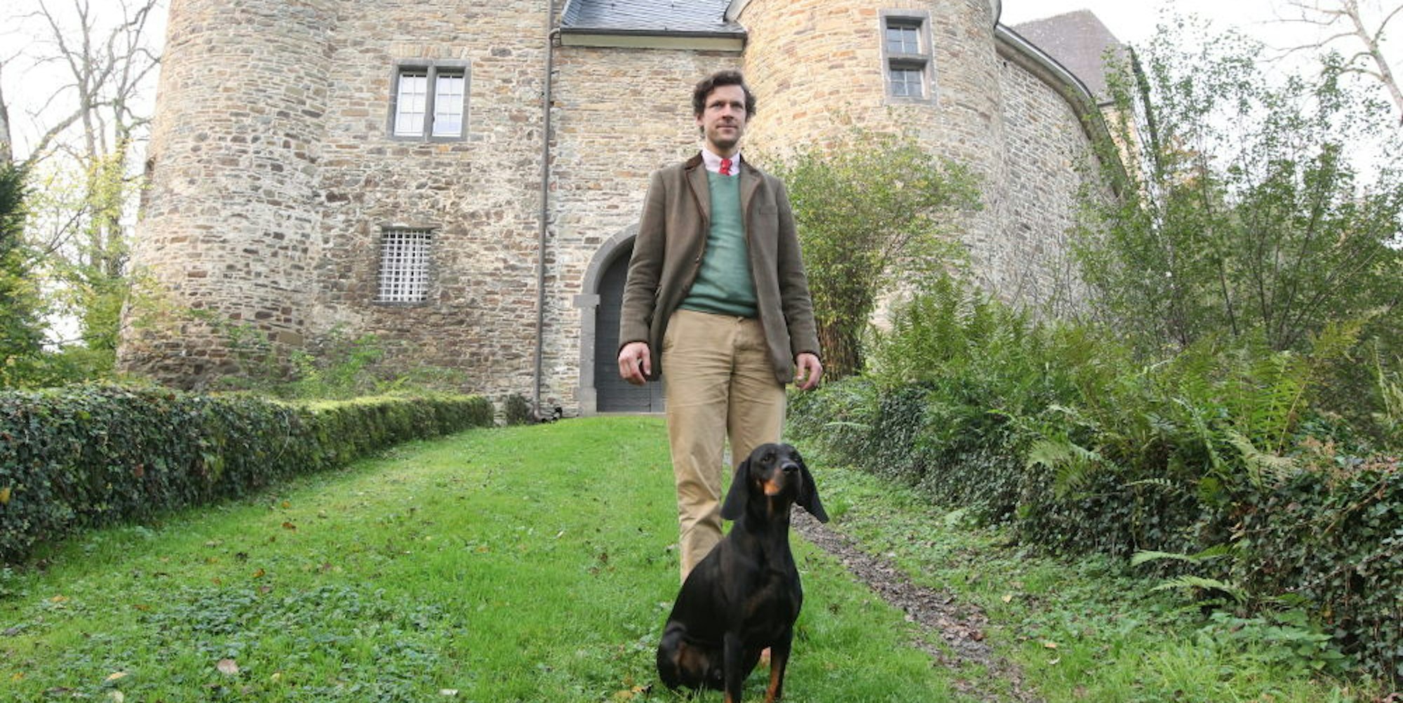 Max Graf Nesselrode und sein Hund Enzo vor dem Bürotrakt von Burg Herrnstein.