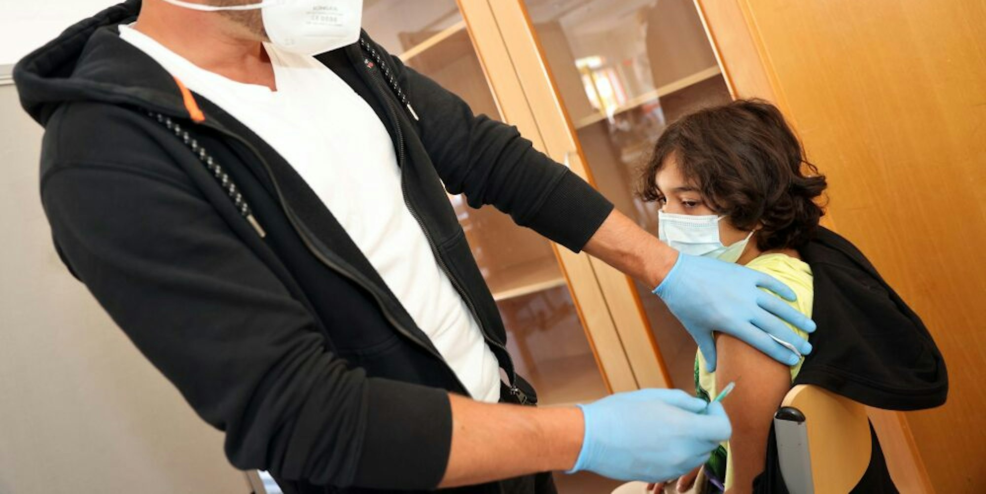 Stelios Nicolaou gibt Schüler Burakhen Bozan die Coronaschutzimpfung.