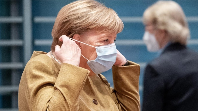 Kanzlerin Angela Merkel setzt Mund-Nasen-Schutz auf (1)