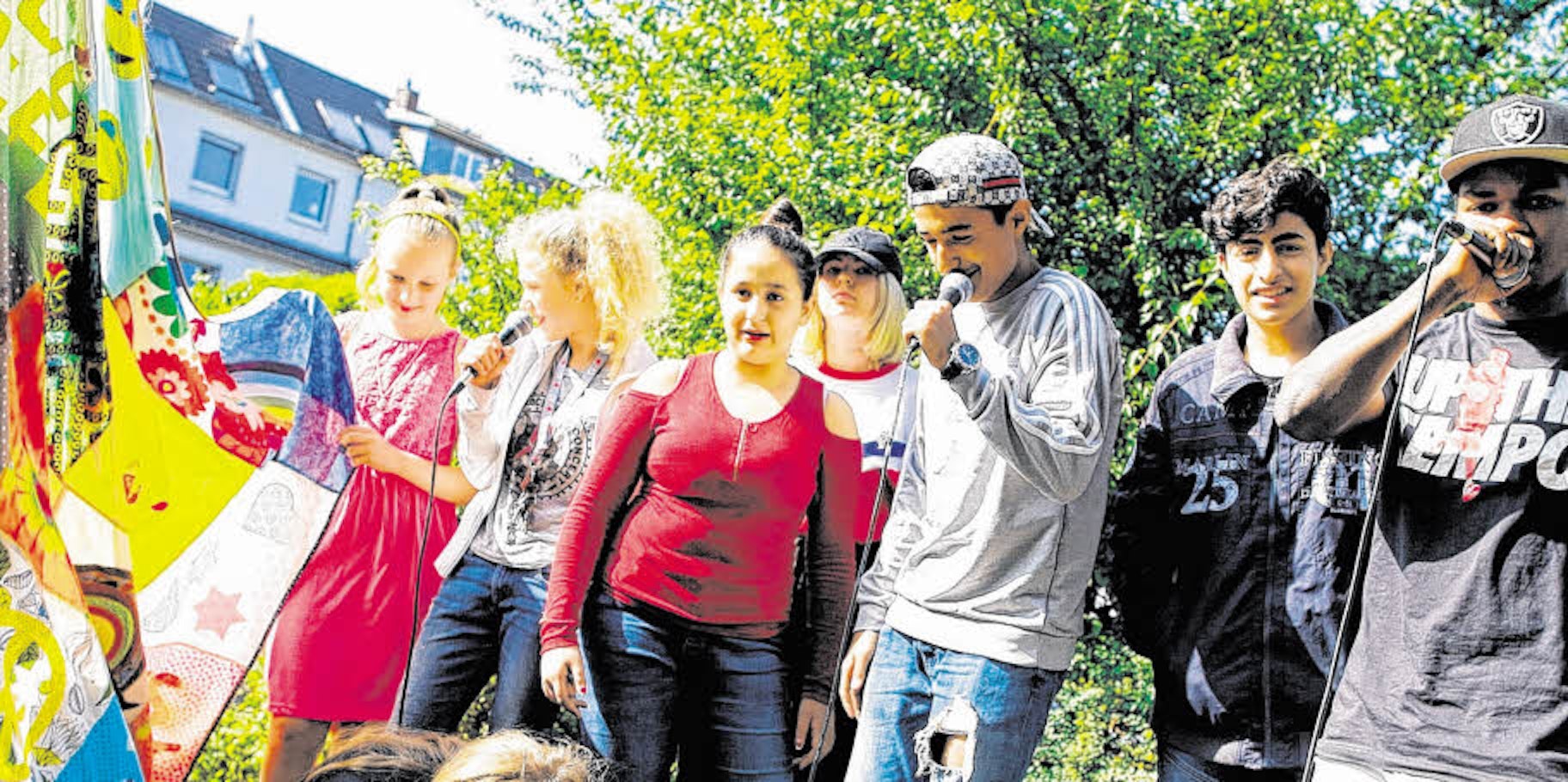 Monika, Isabell, Aya, Eleny, Mohamad und Wassim rappen im Hof des Jugendhauses Treffer.
