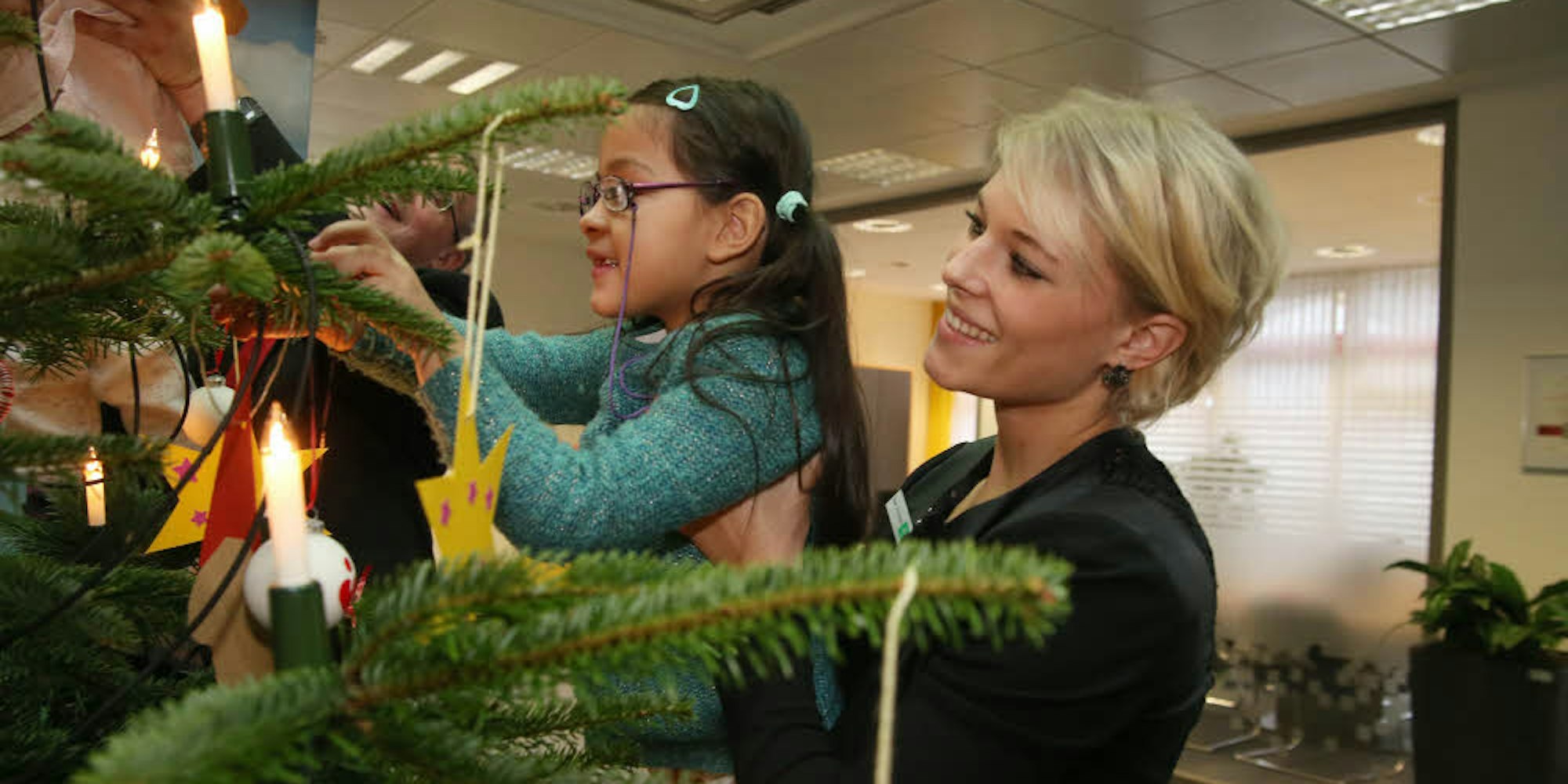 Ein Zettel pro Zweig: Sarah Grützenbach von der AOK half den Vorschulkindern gestern gerne beim Schmücken des Weihnachtswunschbaums.