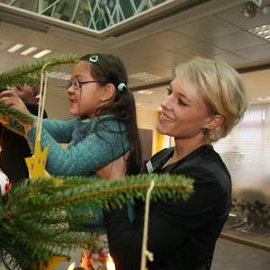 Ein Zettel pro Zweig: Sarah Grützenbach von der AOK half den Vorschulkindern gestern gerne beim Schmücken des Weihnachtswunschbaums.