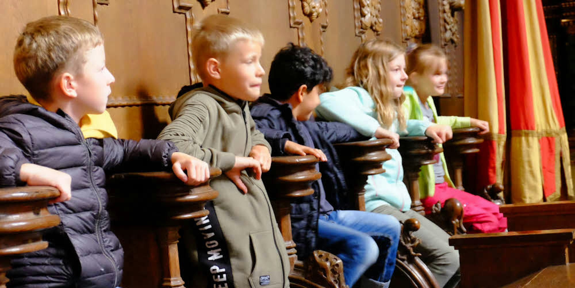 Spaß im Chorgestühl: Die Jungen und Mädchen von der Offenen Ganztagsschule Blankenheim probierten bei der Kirchenführung die Klappsitze im Altarraum der Basilika Steinfeld gerne aus.