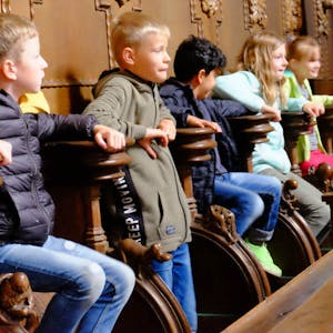 Spaß im Chorgestühl: Die Jungen und Mädchen von der Offenen Ganztagsschule Blankenheim probierten bei der Kirchenführung die Klappsitze im Altarraum der Basilika Steinfeld gerne aus.