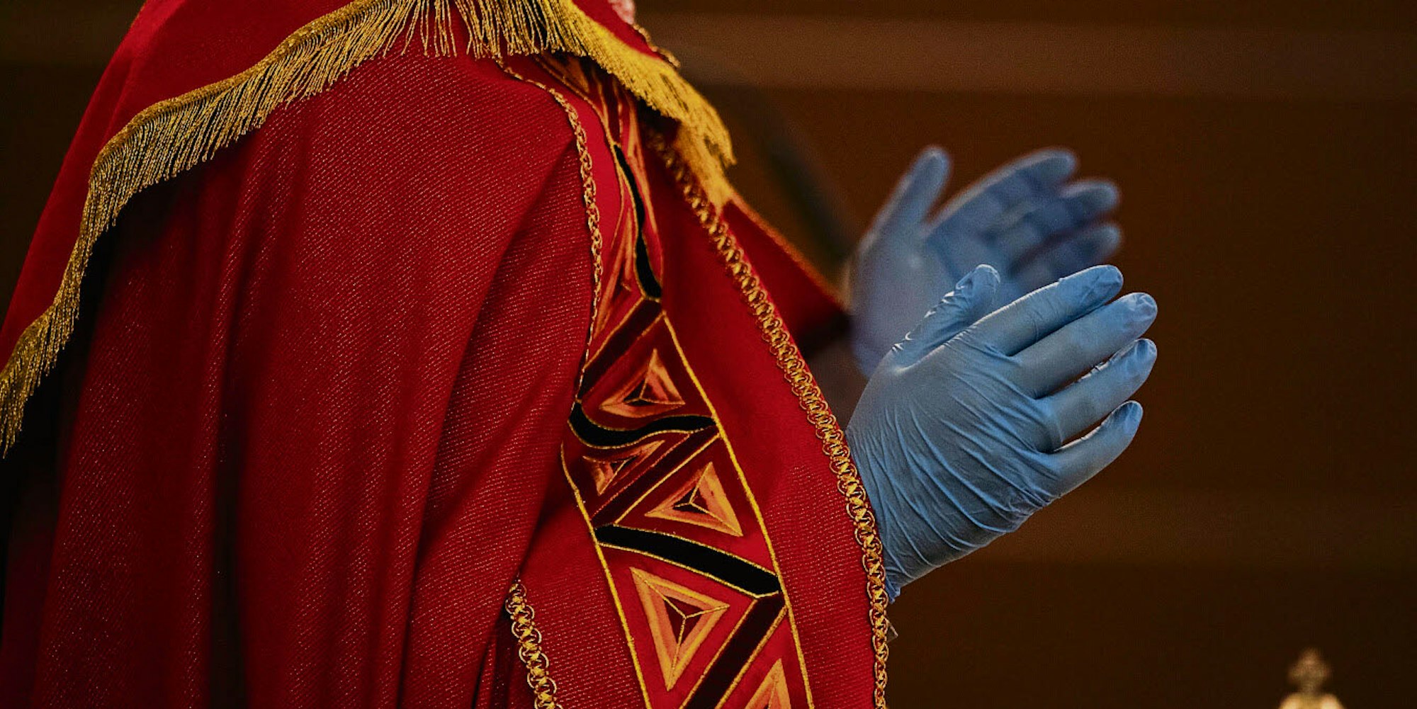 Italienischer Priester mit Mundschutz und Handschuhen während der Karfreitagsliturgie