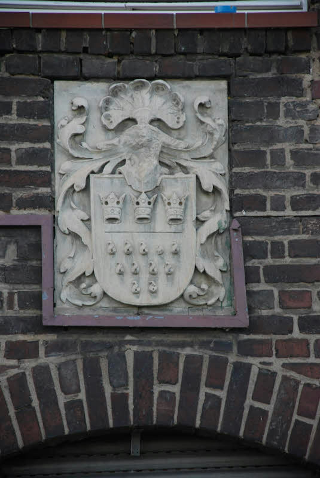 Das Wappen der Kölner Armenverwaltung prangt an der Fassade.