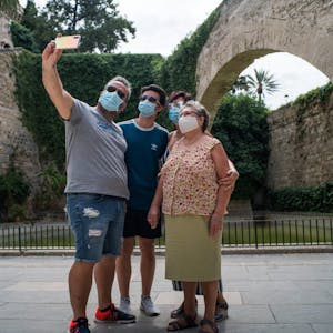 Maskenpflicht auf Mallorca: Eine Touristen-Familie verhält sich neben der Kathedrale von Palma in dieser Hinsicht vorbildlich.