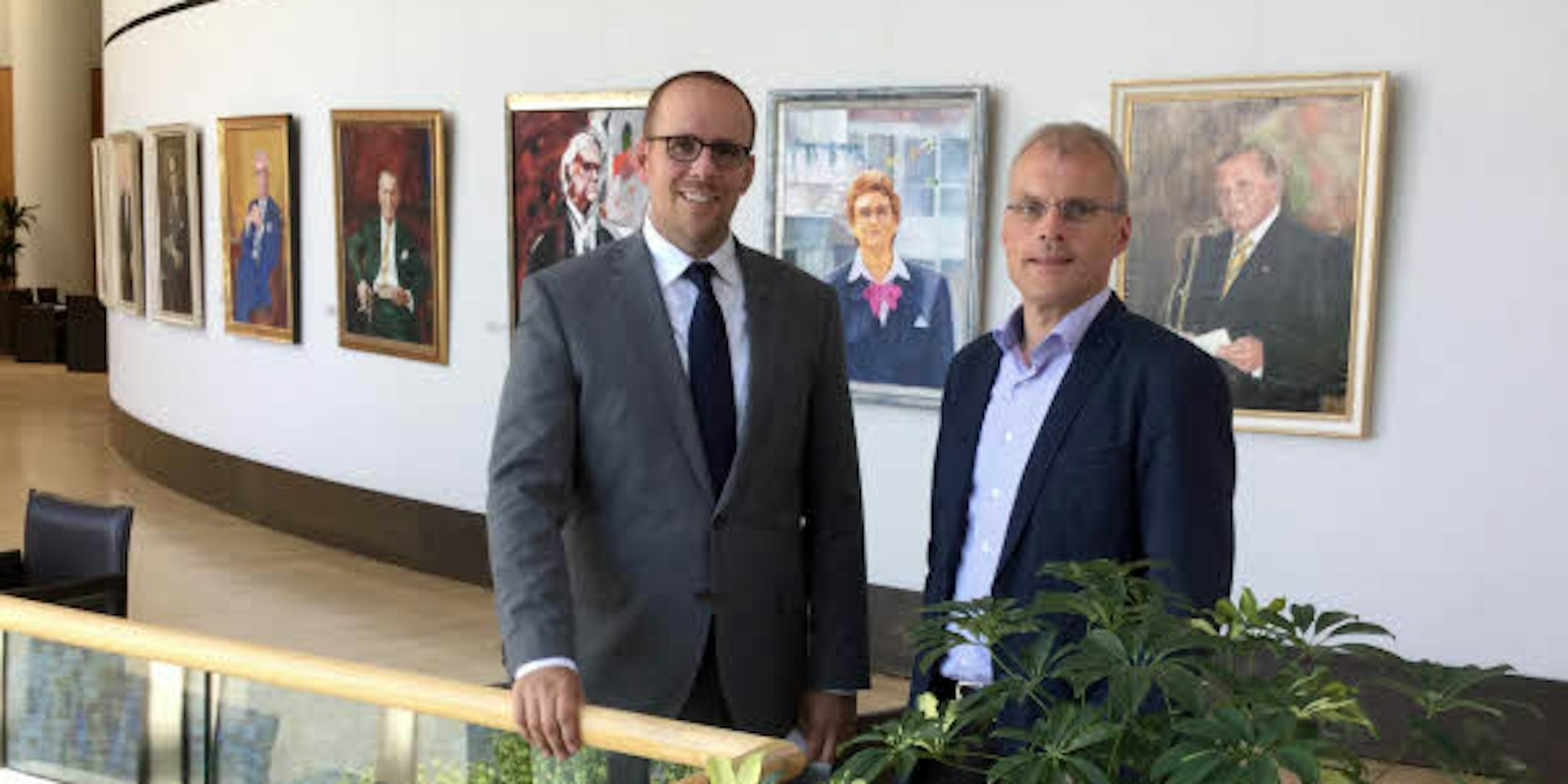 Gebäude mit Aussicht und Kunst: Jörn Freynick (l.) und Oliver Krauß vor der Galerie der bisherigen Präsidentinnen und Präsidenten des Landtags Nordrhein-Westfalen.