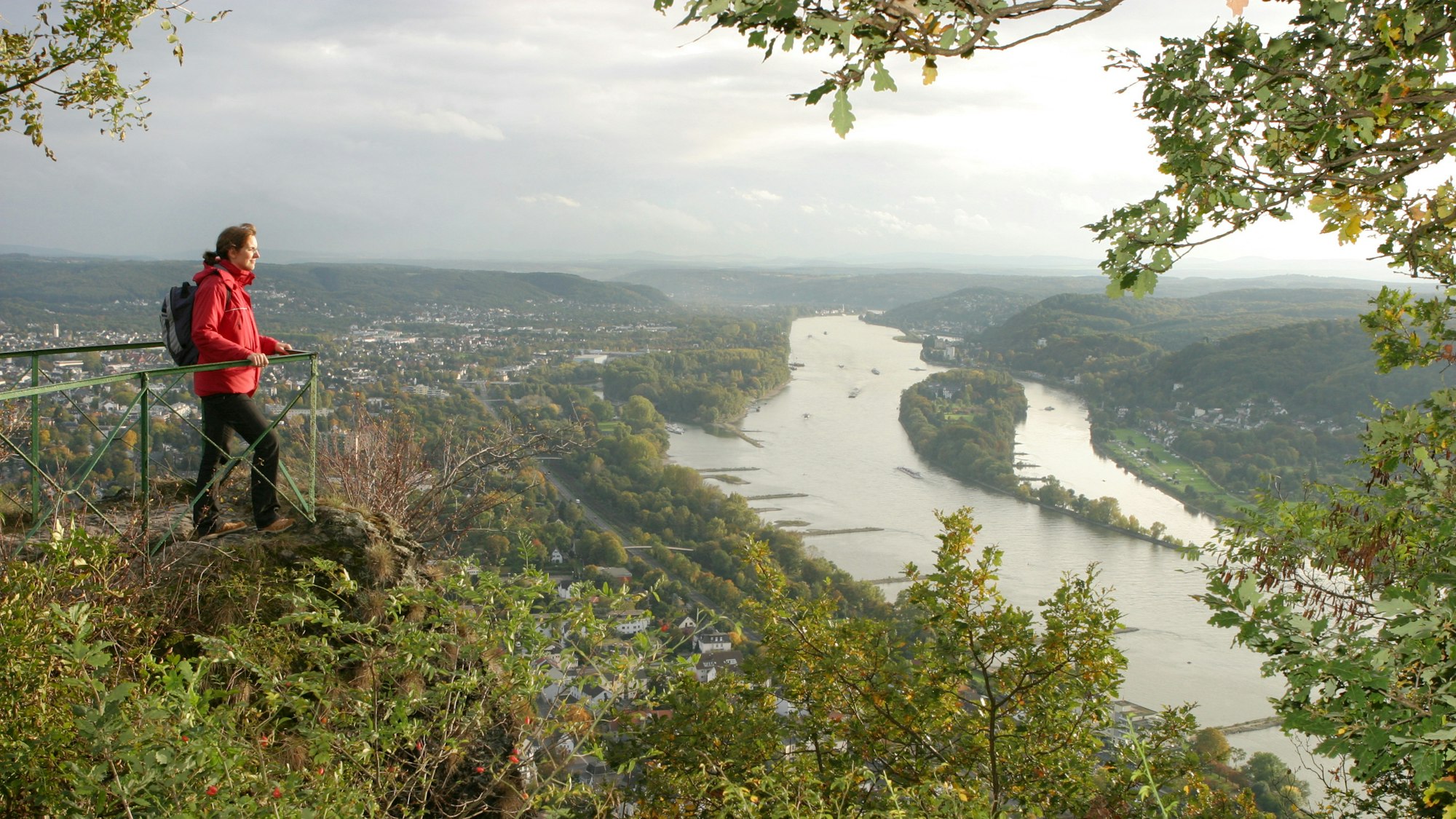 Wanderin blickt von einem Aussichtspunkt auf den Rhein
